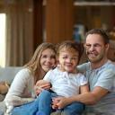 Zoe with her family on a clean sofa